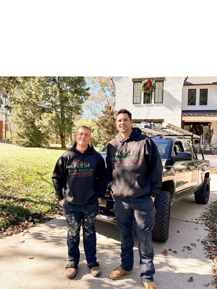 Thin Red Line Holiday Lighting team member with Christmas light installation